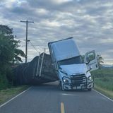 Ein weißer Laster ist auf der Straße umgekippt. Die Ladung ist seitlich heruntergefallen.