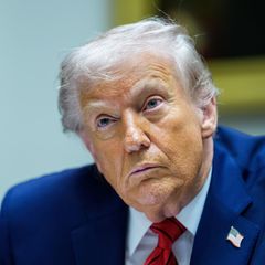 US-Präsident Donald Trump sitzt im Anzug an einem Tisch und hört zu