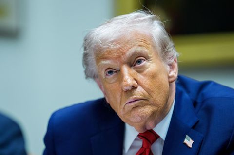 US-Präsident Donald Trump sitzt im Anzug an einem Tisch und hört zu