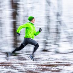 Joggen läuft durch einen verschneiten Wald.
