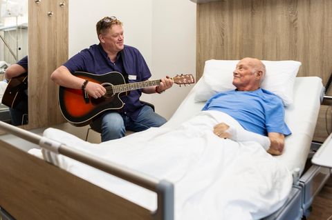 Im Krankenhaus bietet Dirk Bülow einem Patienten ein Ständchen dar