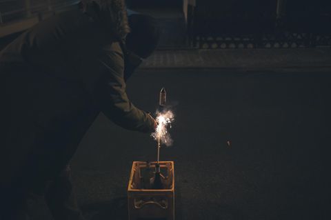 Person zündet eine Feuerwerksrakete an