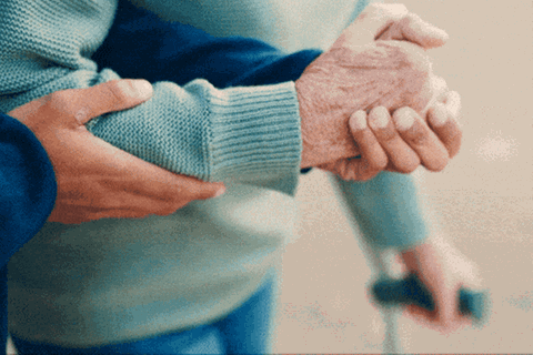 Pflegeversicherung: Stützende Hände helfen einer alten Person