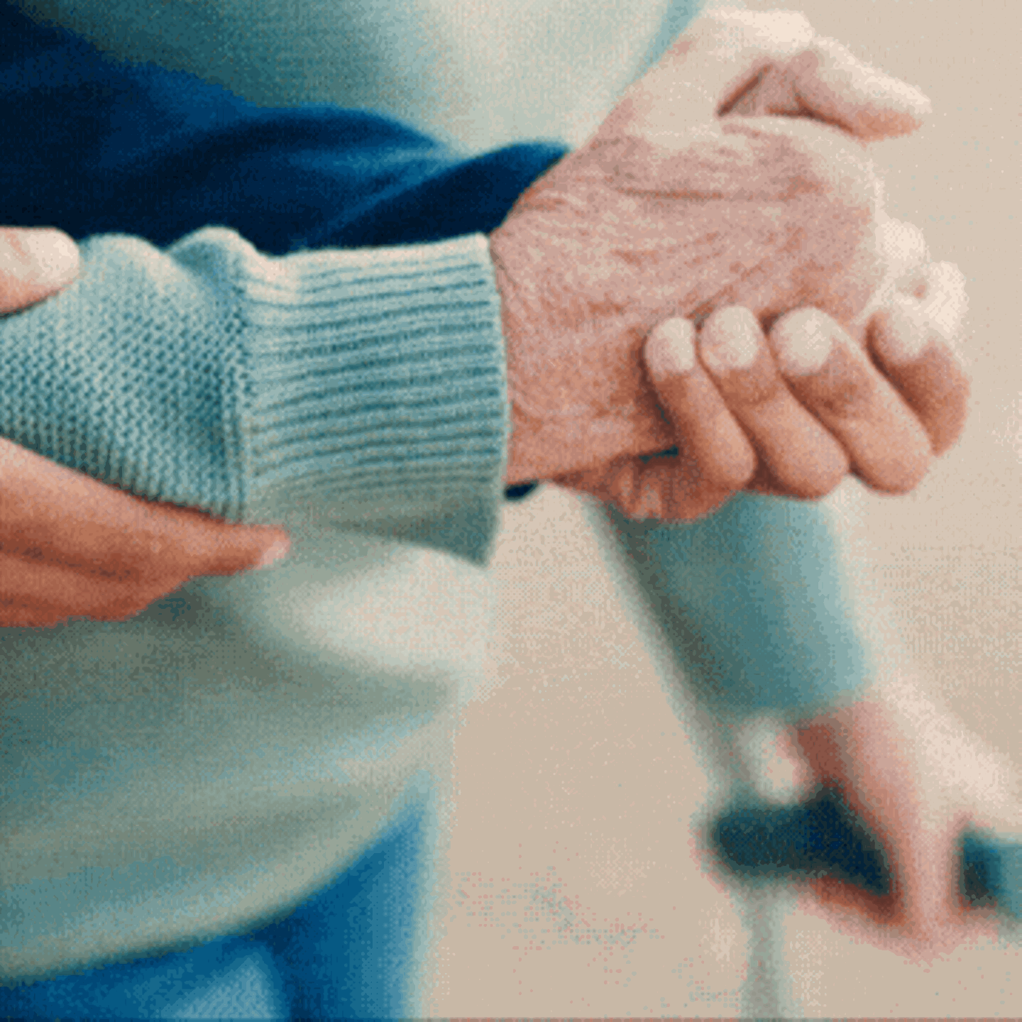 Pflegeversicherung: Stützende Hände helfen einer alten Person