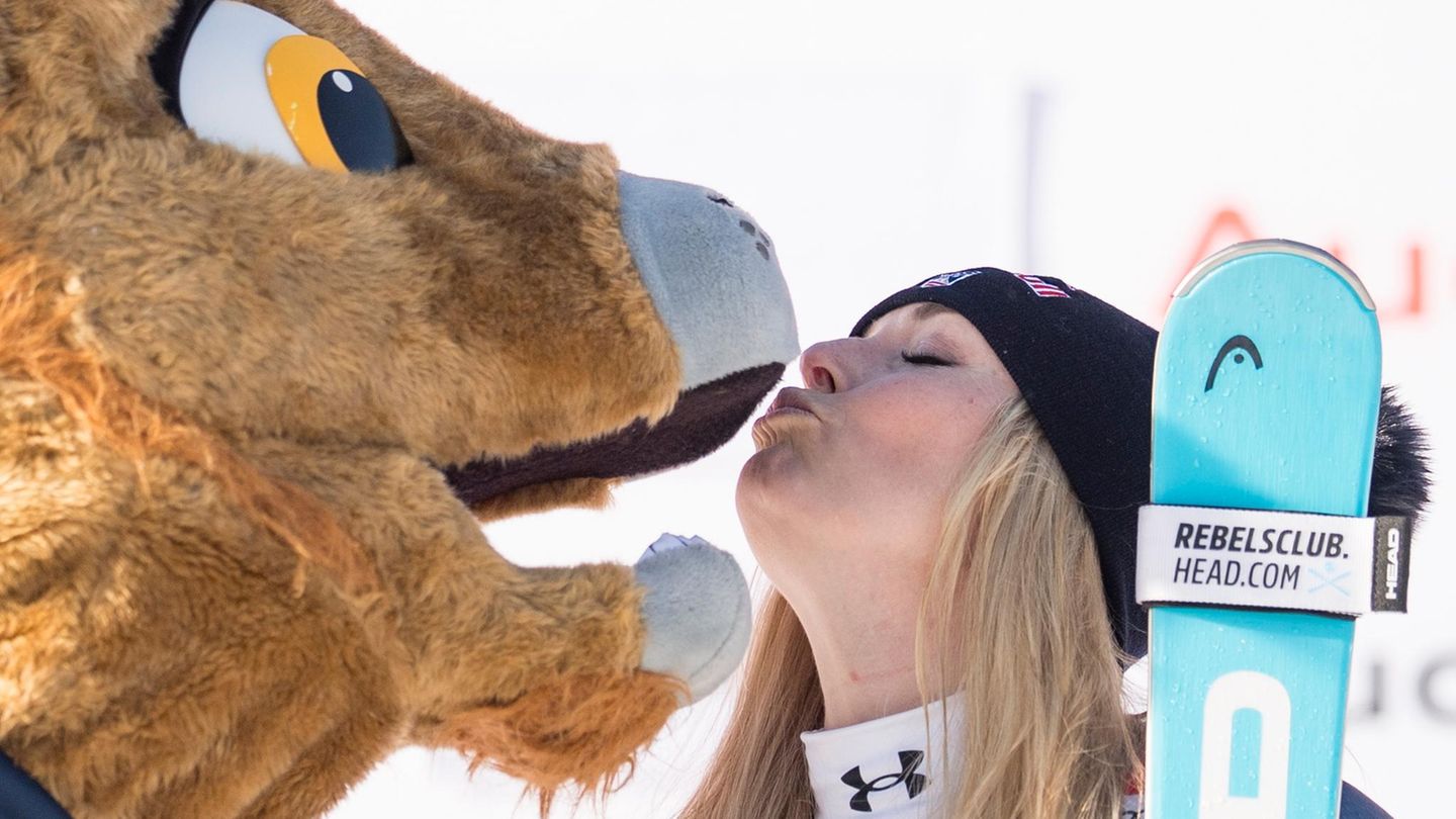 St. Moritz, Schweiz. Die erstplatzierte Lindsey Vonn aus den USA posiert nach ihrem Sieg im Abfahrtsrennen der Damen beim FIS Skiweltcup mit Maskottchen Moritz auf dem Podium