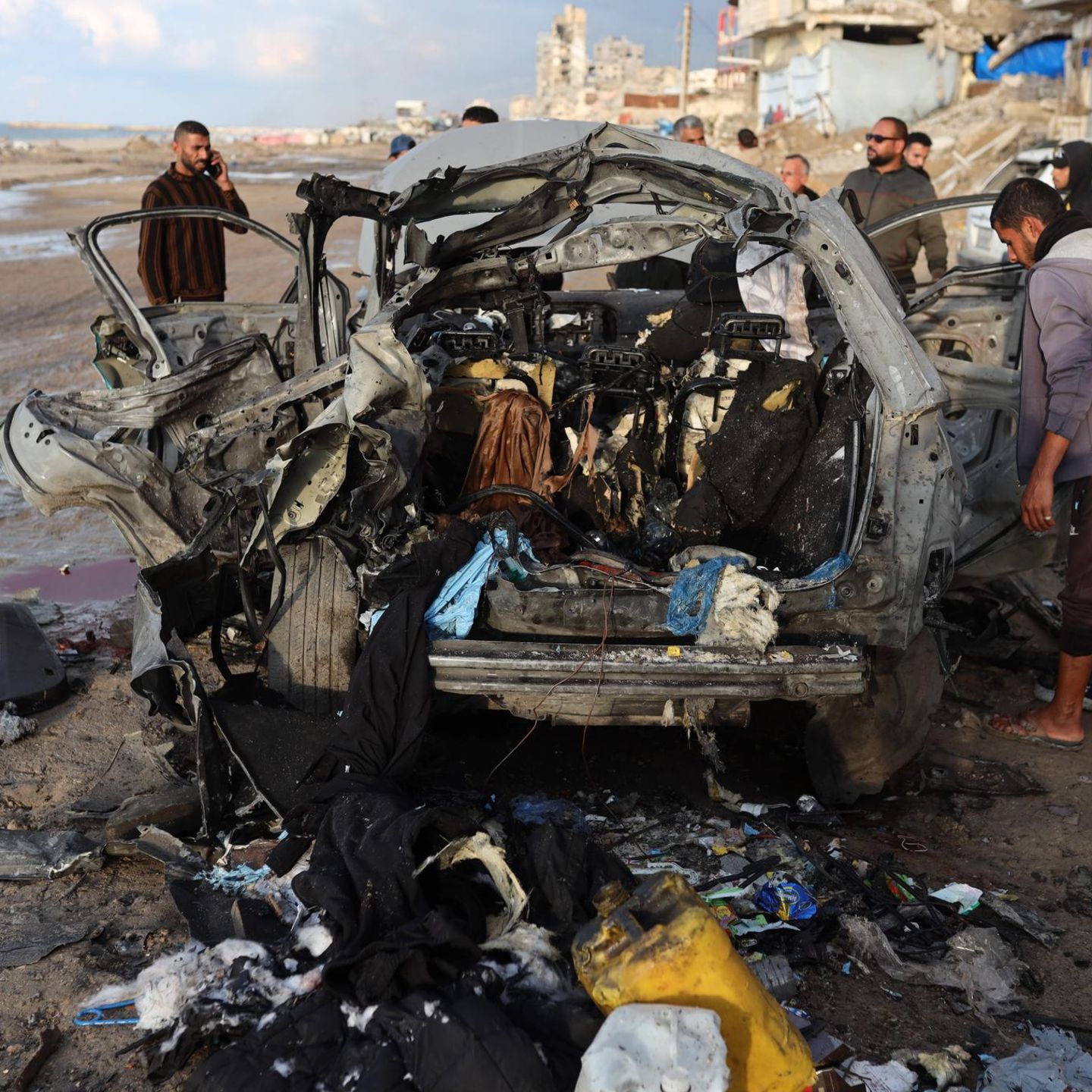 Palästinenser inspizieren den Ort eines israelischen Angriffs auf ein Auto in Gaza-Stadt