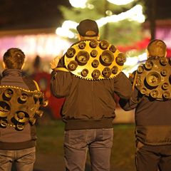 Drei Mitglieder der Brauchtumsgruppe Weihnachtsmänner e.V. stehen mit Schellengeläut auf dem Weihnachtsmarkt in Altenbrak. Am er