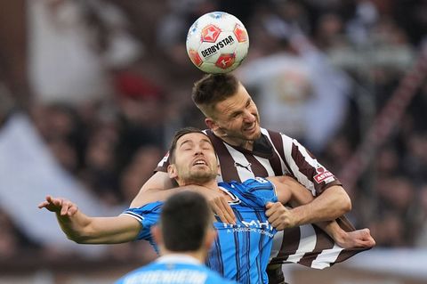 Marvin Pieringer verliert zwar das Kopfballduell gegen Karol Mets (r, FC St. Pauli), war aber der beste Heidenheimer. Foto: Marc
