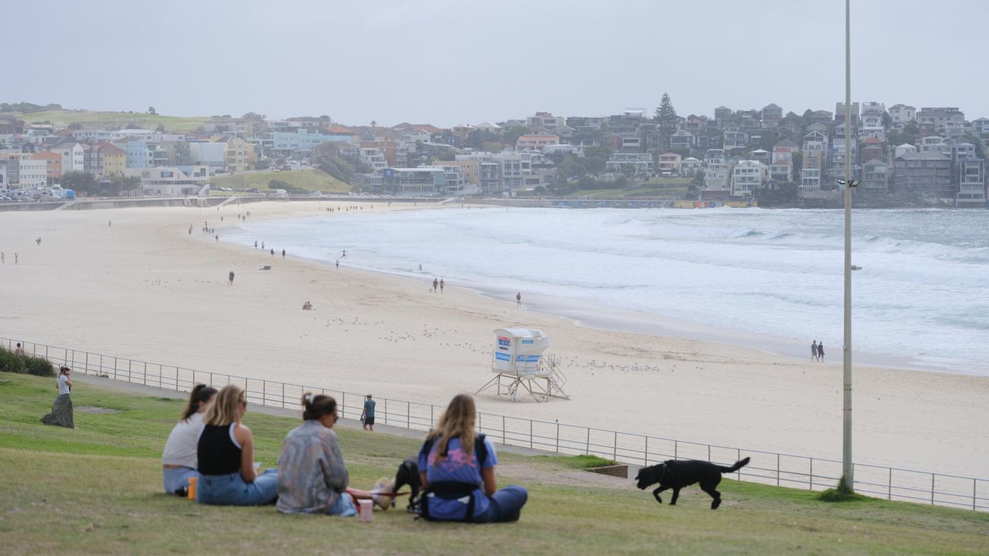Am Tag nach dem Anschlag blicken Menschen auf den Bondi Beach – jenen Platz, der vom Feier- zum Tatort wurde