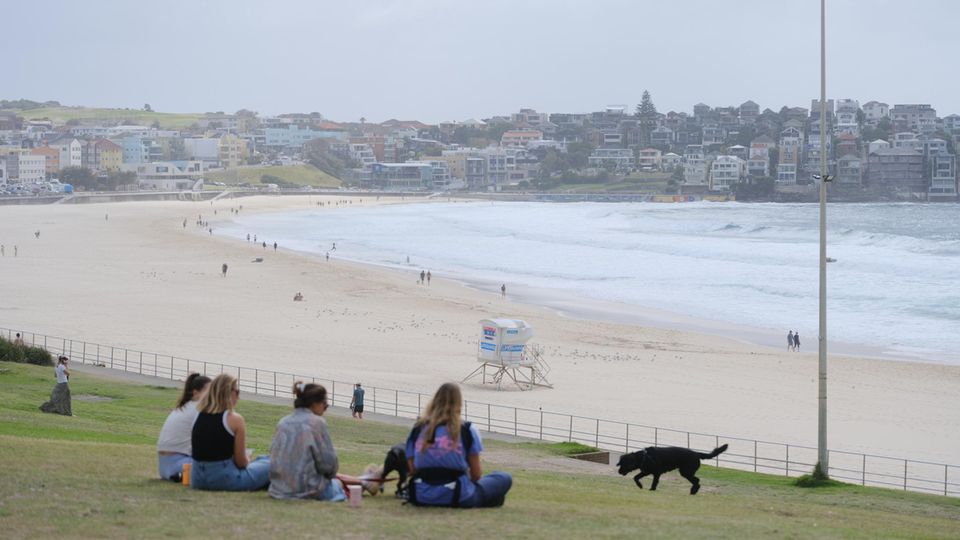 Am Tag nach dem Anschlag blicken Menschen auf den Bondi Beach – jenen Platz, der vom Feier- zum Tatort wurde