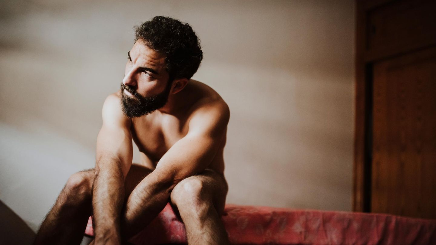 Ein Mann sitzt auf einer Bettkante und schaut nachdenklich (Symbolbild NoFap)