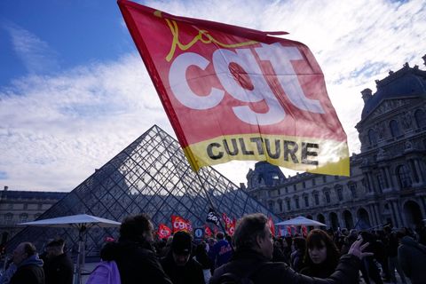 Angestellte zeigen eine Flagge der Gewerkschaft CGT vor dem Louvre, nachdem sie für einen Streik gestimmt haben. Foto: Michel Eu