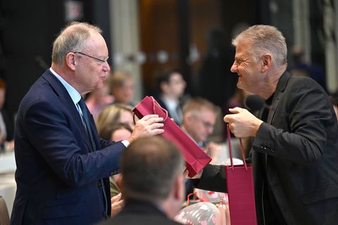 Geburtstagsgruß im Parlament: SPD-Fraktionschef Politze (r) überreicht Ex-Ministerpräsident Weil (l) eine Flasche Wein. Foto: Sh