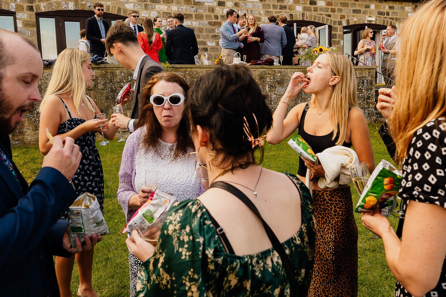 Protokollpunkt: Begrüßungsgetränk. "Ich greife gern auf Elemente von Streetphotography zurück, gerade bei der Begrüßung der Gäste. Ich liebe es, wie die Augen durch den Bildausschnitt hüpfen und immer wieder Neues entdecken. Bei dieser Hochzeit gab es Chips statt Kanapees." Die Jury würdigte auch diese Aufnahme der britischen Fotografin.   Finalistin in der Kategorie "Break the Rules": Jenna Kathleen, Großbritannien