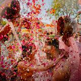 Zwei Menschen werden bei ihrer Hochzeit mit Blüten und Wasser überschüttet