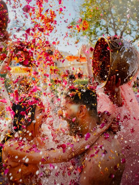 Zwei Menschen werden bei ihrer Hochzeit mit Blüten und Wasser überschüttet