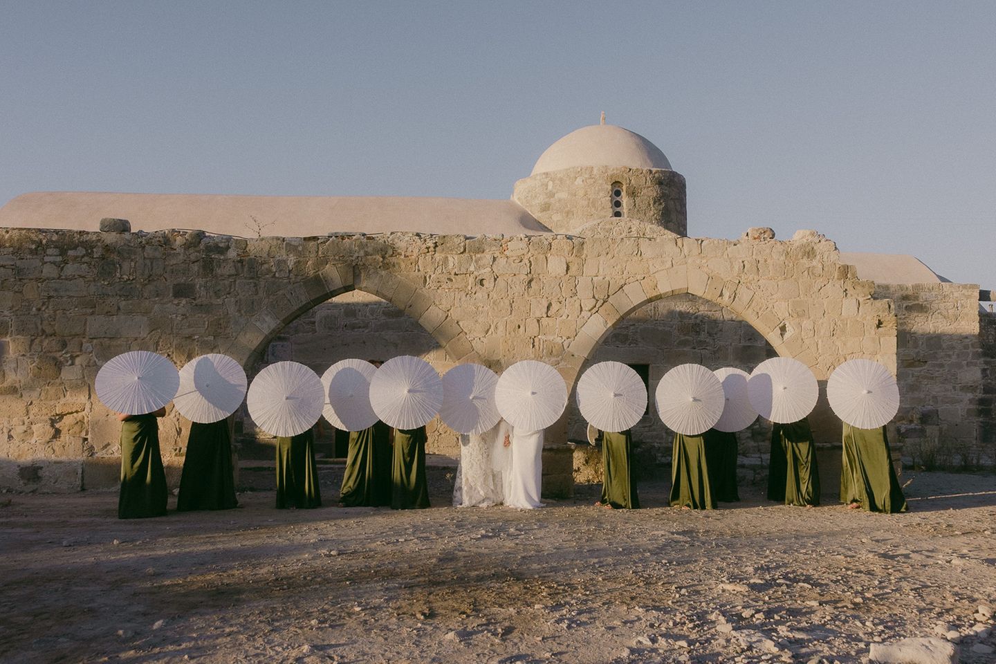 Im Kreis der Menschen, die am meisten zählen: Für seine Auslandshochzeit wählte dieses Paar Zypern als Destination. "Das Bild wurde kurz nach der Zeremonie aufgenommen, im goldenen Licht des späten Nachmittags, eingerahmt von altem Gemäuer unter dem offenem Himmel," schreibt die Fotografin. "Als würde die Zeit für einen Moment innehalten."   Finalistin in der Kategorie "I-do Crew": Karina Leonenko, Zypern