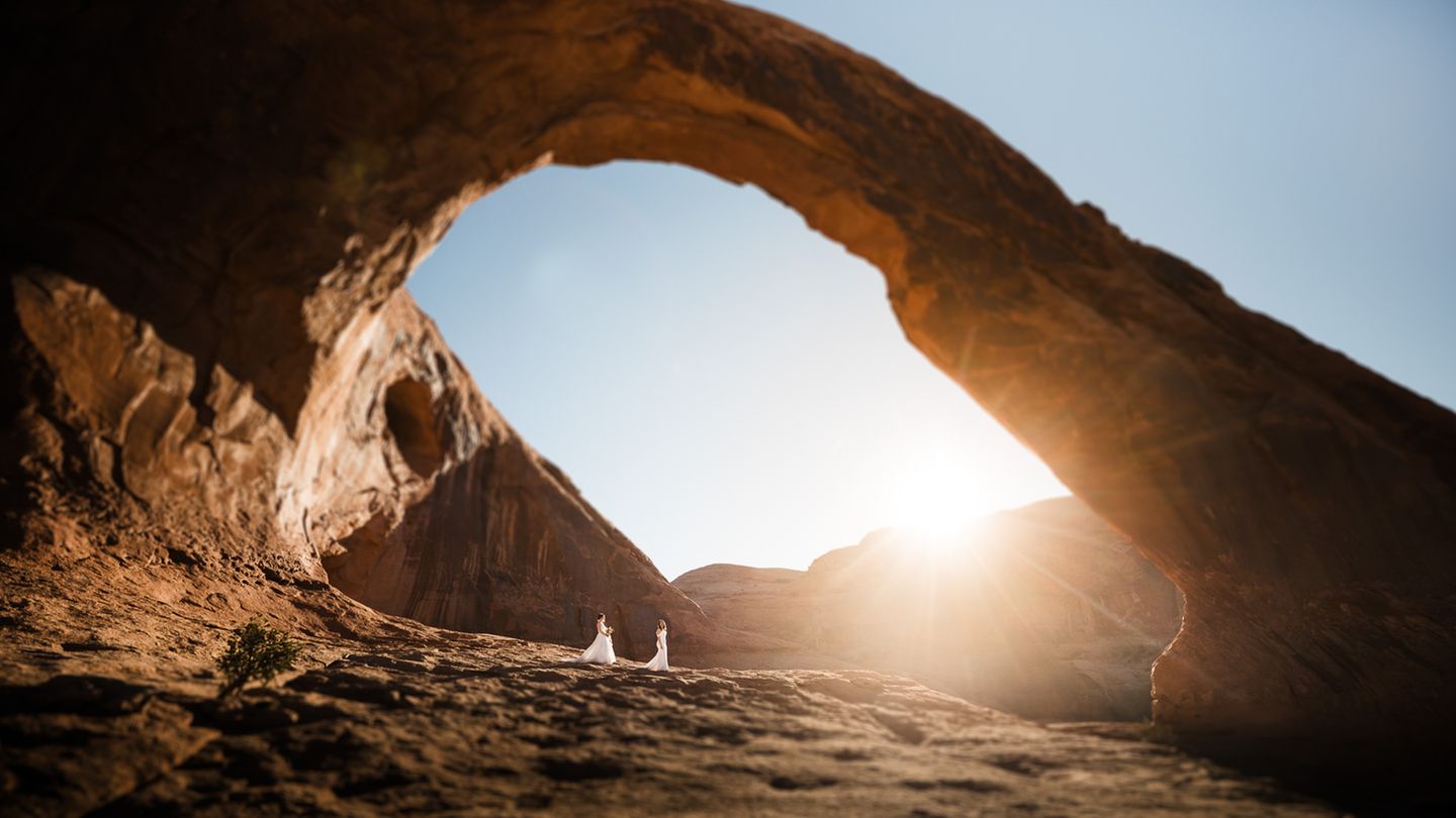 Der Corona Arch, ein Sandsteinbogen in der Nähe von Moab im US-Staat Utah, spannt sich in mehr als 30 Meter Höhe über einem Brautpaar. Die überwältigende Erfahrung in der Natur mache uns sofort klar, was wirklich wichtig ist, schreibt Hochzeitsfotografin Aimee Flynn. "Ich denke, deshalb sind diese Natur-Shootings für Paare so wichtig." ⁠  Finalistin "Epic Location": Aimee Flynn, USA