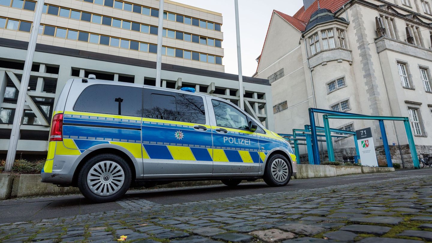 Vor dem Landgericht Bielefeld steht ein Polizeifahrzeug. Hier beginnt ein Prozess um Betrug und Bestechung in der Bauwirtschaft.