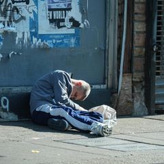 Ein süchtiger Mann sitzt auf der Straße und wirkt weggetreten. Fentanyl steht im Zentrum der Drogenkrise in den USA