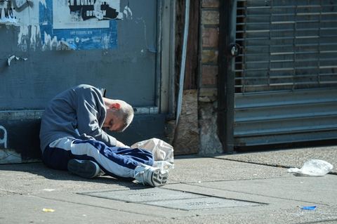 Ein süchtiger Mann sitzt auf der Straße und wirkt weggetreten. Fentanyl steht im Zentrum der Drogenkrise in den USA
