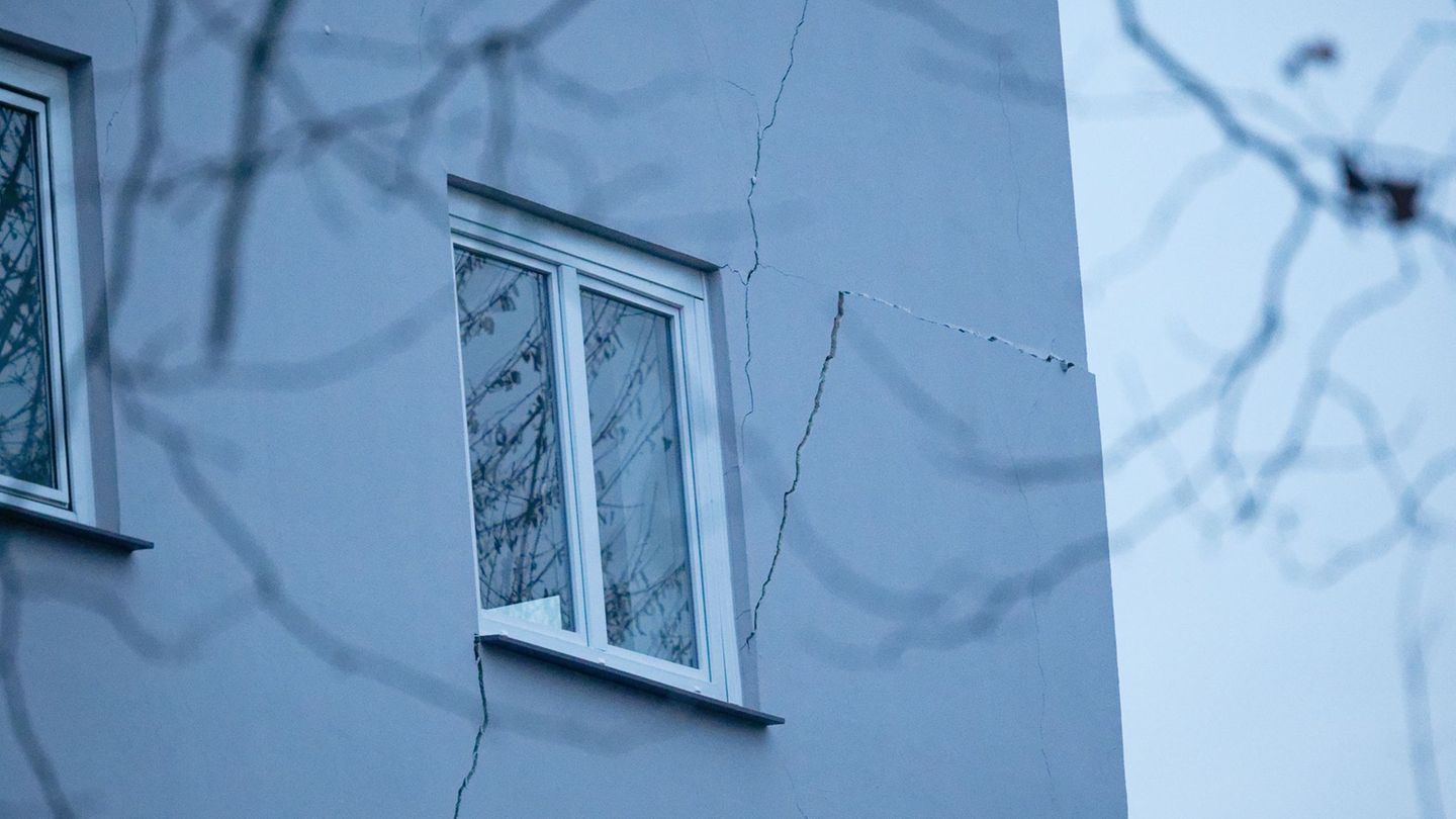 Rissen sind an der Fassade eines Mehrfamilienhauses zu sehen. Weil an mehreren Stellen der Boden abgesackt ist, ist das zweistöc