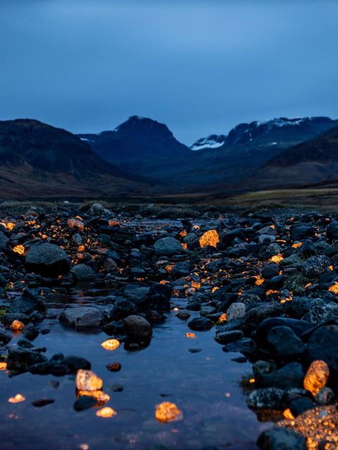 Sodalithsteine leuchten in einer Landschaft im Süden Grönlands in der Dämmerung