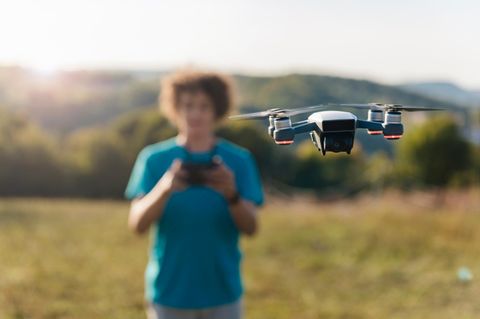 Junge steuert einen Quadrocopter