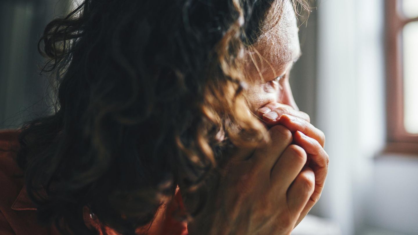 Eine Frau schaut nachdenklich aus dem Fenster. Ist sie auf Kreuzfahrt?