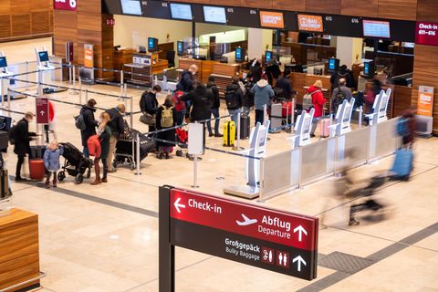 Menschen stehen am Check-In Schalter am Flughafen Berlin Brandenburg (Symbolbild)