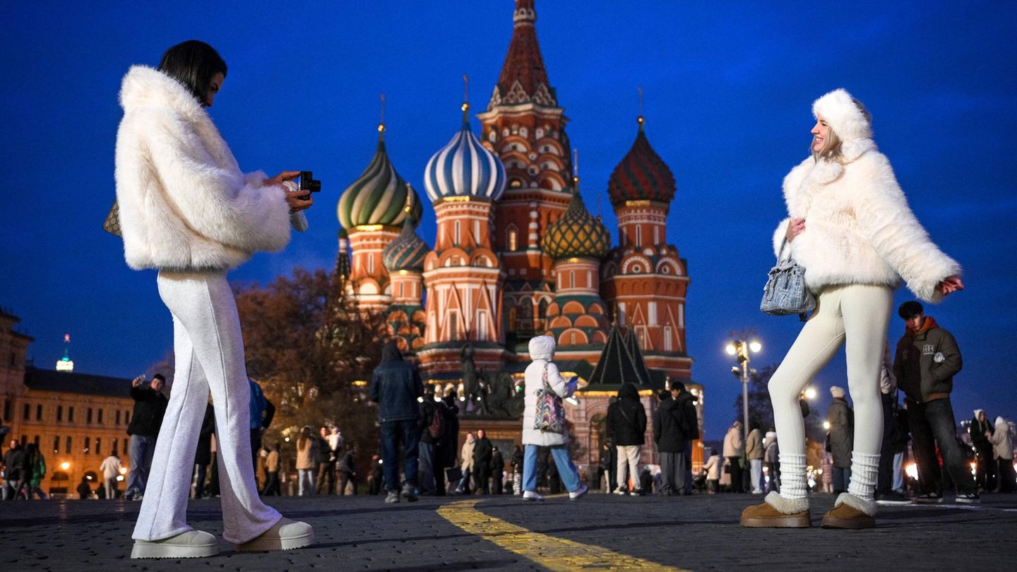 zwei junge Frauen stehen vor der Kathedrale in Moskau und fotografieren sich
