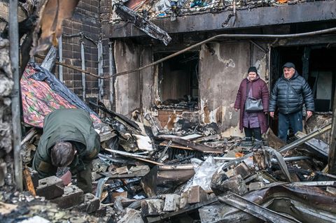 Menschen in einem zerstörten Gebäude nach einem Luftangriff in der Ukraine, Kiew