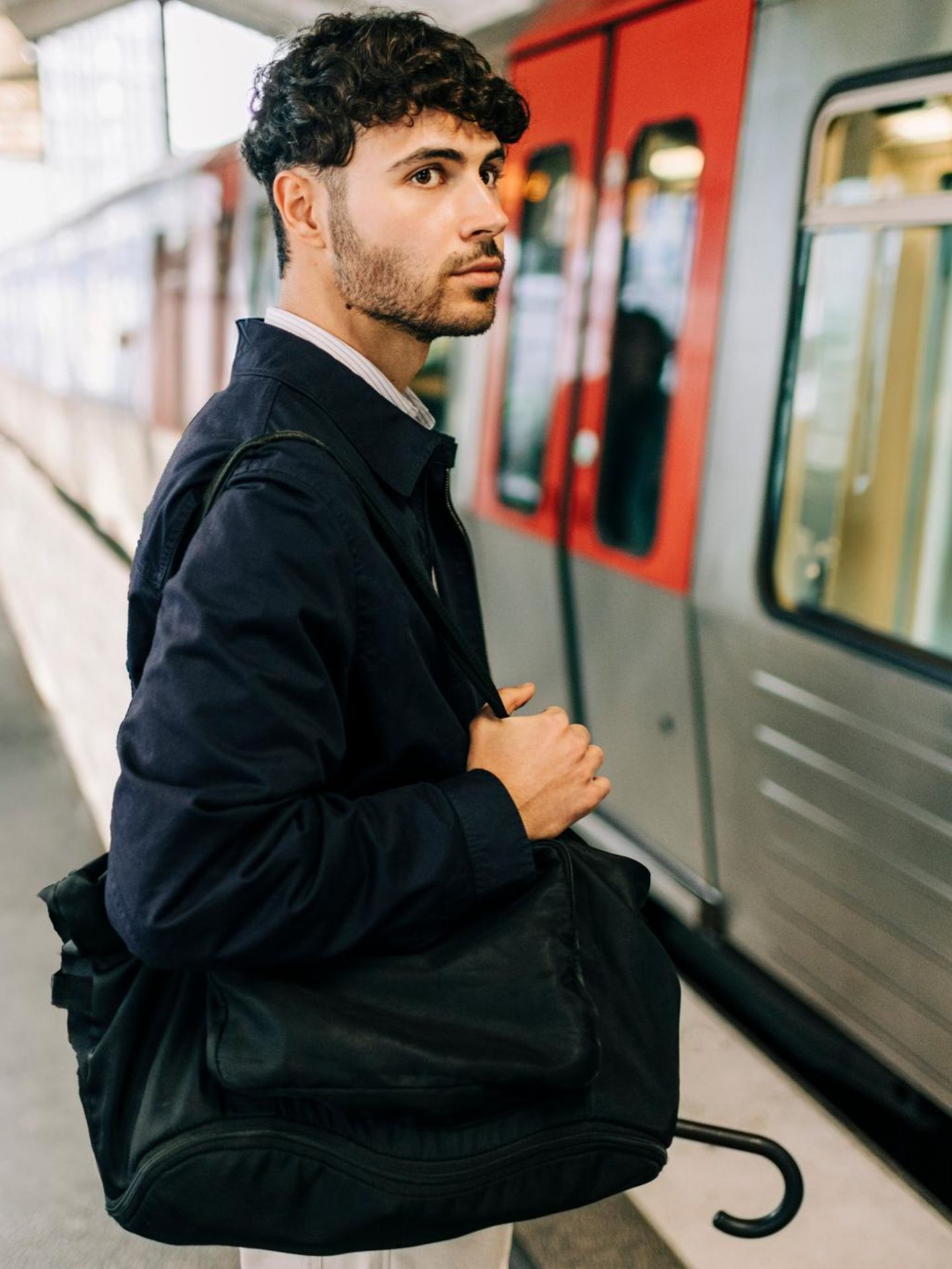 Handwerker und Büroangestellter stehen am Bahnsteig, wo gerade die U-Bahn eingefahren ist – wer hat mehr Gehalt?