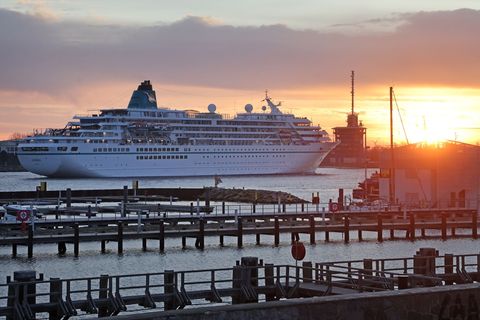 Anlauf bei Sonnenaufgang: "Amadea" fährt in Warnemünde ein. Foto: Bernd Wüstneck/dpa