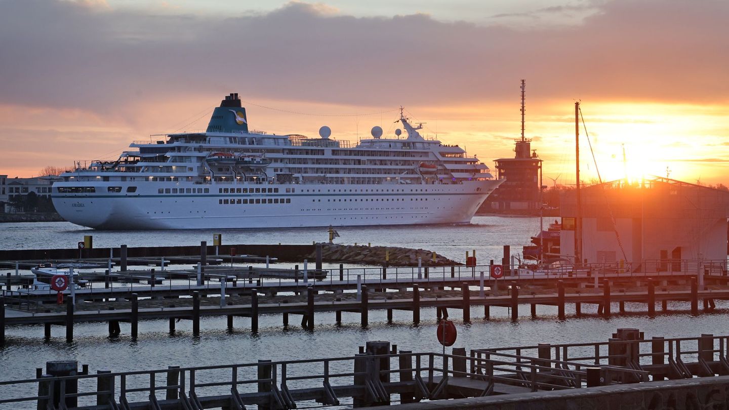 Anlauf bei Sonnenaufgang: "Amadea" fährt in Warnemünde ein. Foto: Bernd Wüstneck/dpa