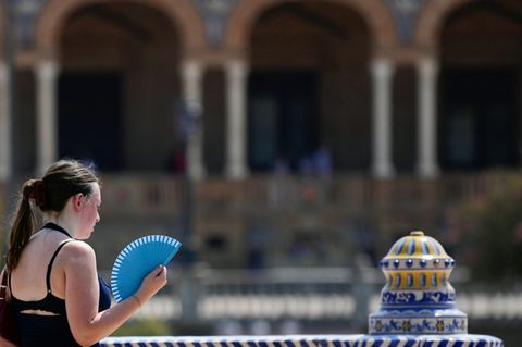 Frau mit Fächer während Hitzwelle im August in Sevilla