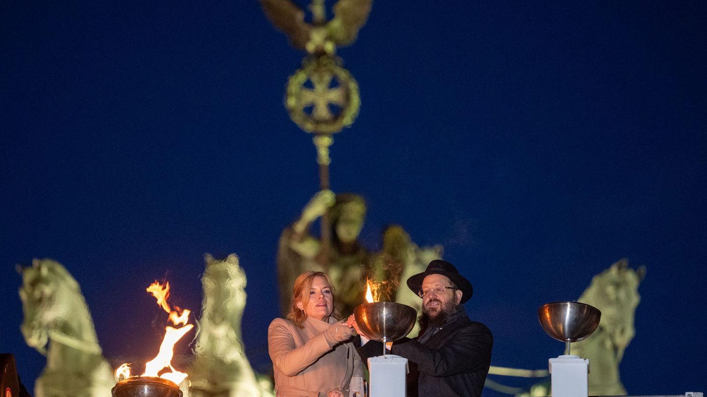 Bundestagspräsidentin Julia Klöckner und Rabbiner Yehudi Teichtal entzünden ein Licht. Foto: Soeren Stache/dpa
