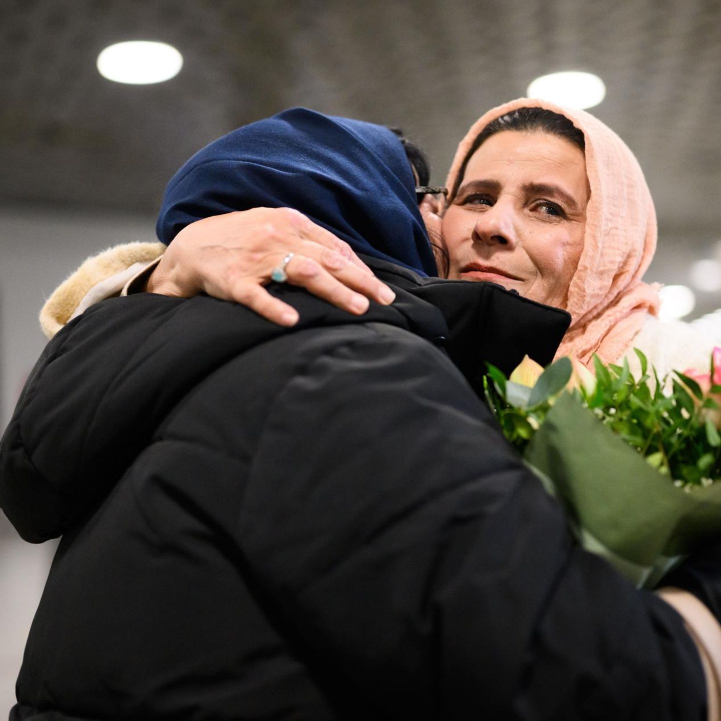 Eine Frau mit Kopftuch umarmt eine andere – Deutschland nimmt Menschen aus Afghanistan auf