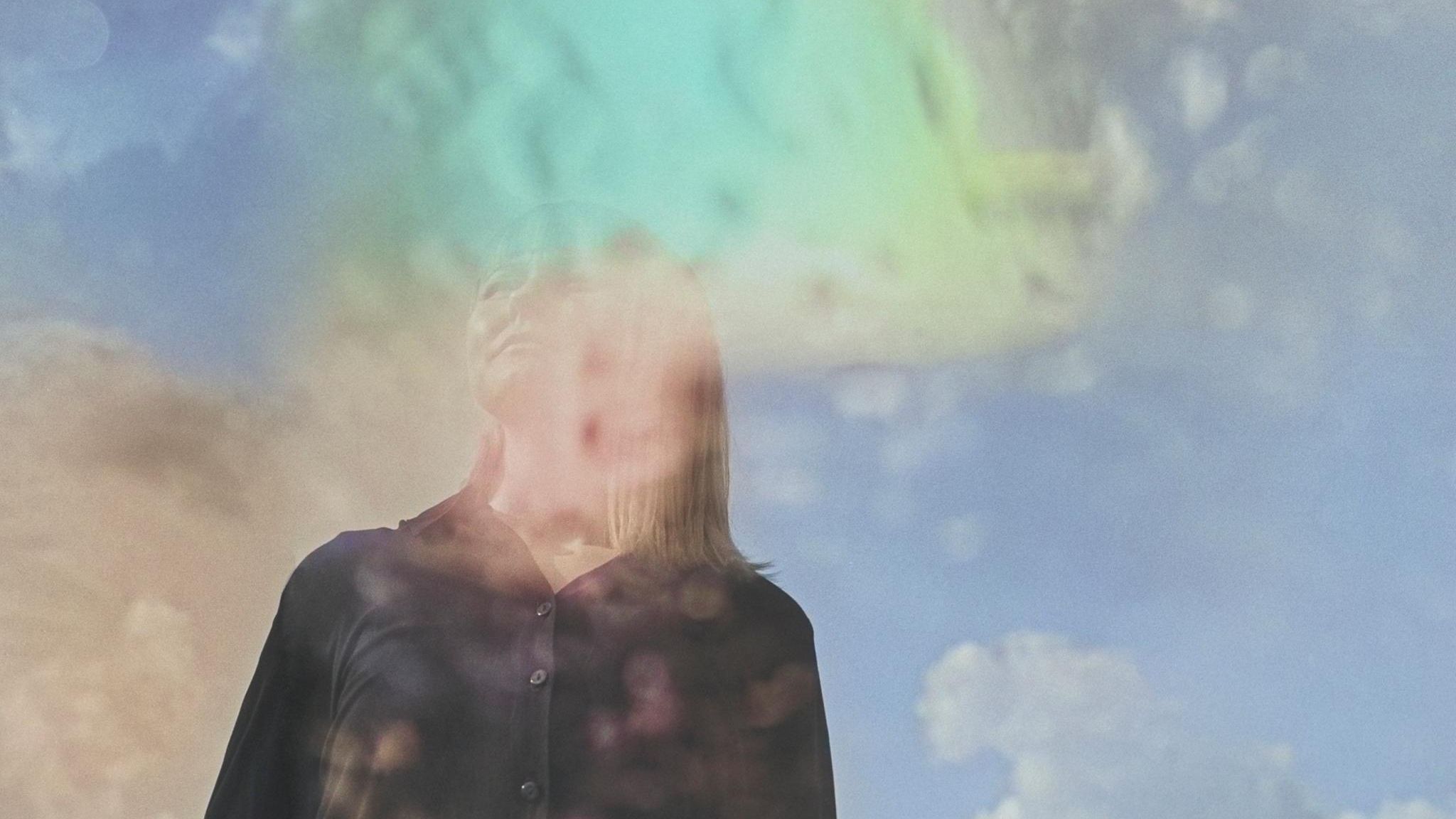 Künstlerisches Bild mit Mehrfachbelichtung – eine Frau schaut träumerisch in die Ferne