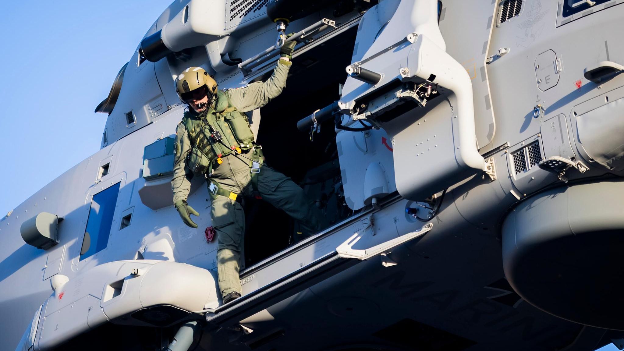 Ein Soldat der Bundeswehr schaut aus einem Helikopter