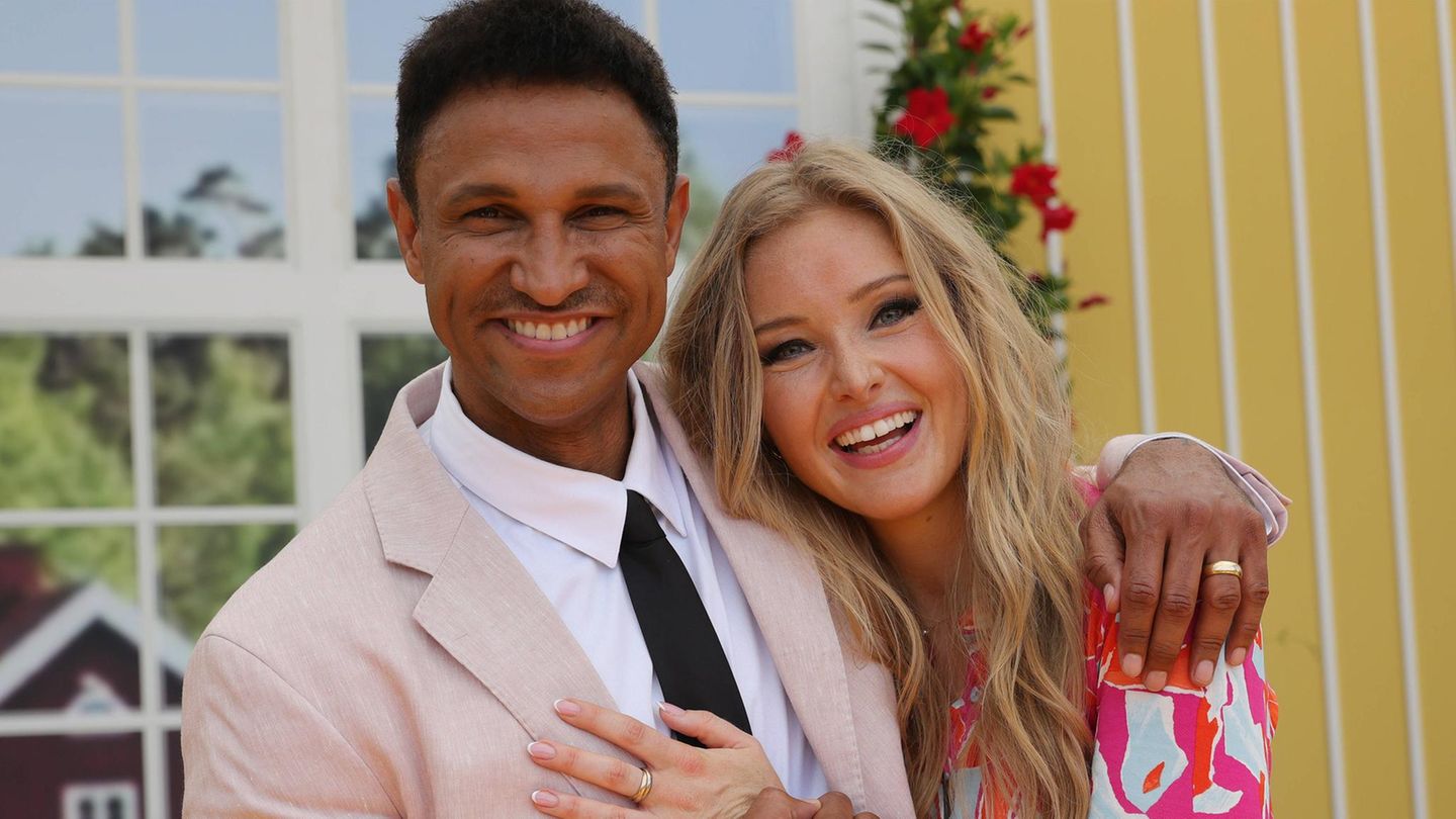 Daniel Aminati und Patrice stehen Arm in Arm und lächeln in die Kamera.