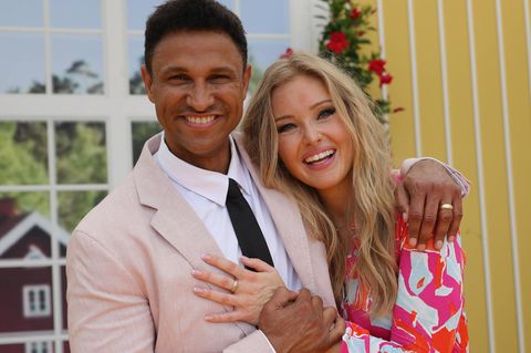 Daniel Aminati und Patrice stehen Arm in Arm und lächeln in die Kamera.