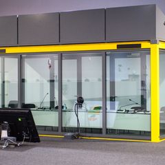 Blick auf den leeren Glaskasten im Gerichtssaal des temporären Gerichtsgebäudes vom Landgericht Magdeburg, in dem normalerweise