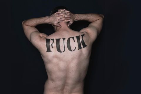Ein männlicher Rücken mit einem "Fuck"-Tattoo
