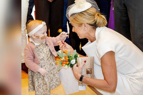 Süße Begegnung im Zentrum für Kinderonkologie in Utrecht: Ein kleines Mädchen reicht Königin Máxima eine Blume.
