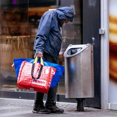 Ein Obdachloser sucht in einem Mülleimer nach Pfandflaschen (Symbolbild)