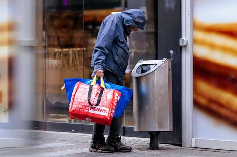 Ein Obdachloser sucht in einem Mülleimer nach Pfandflaschen (Symbolbild)