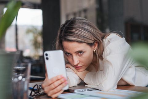 Eine Frau schaut auf das Smartphone. Nutzt Sie Whatsapp