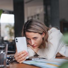 Eine Frau schaut auf das Smartphone. Nutzt Sie Whatsapp