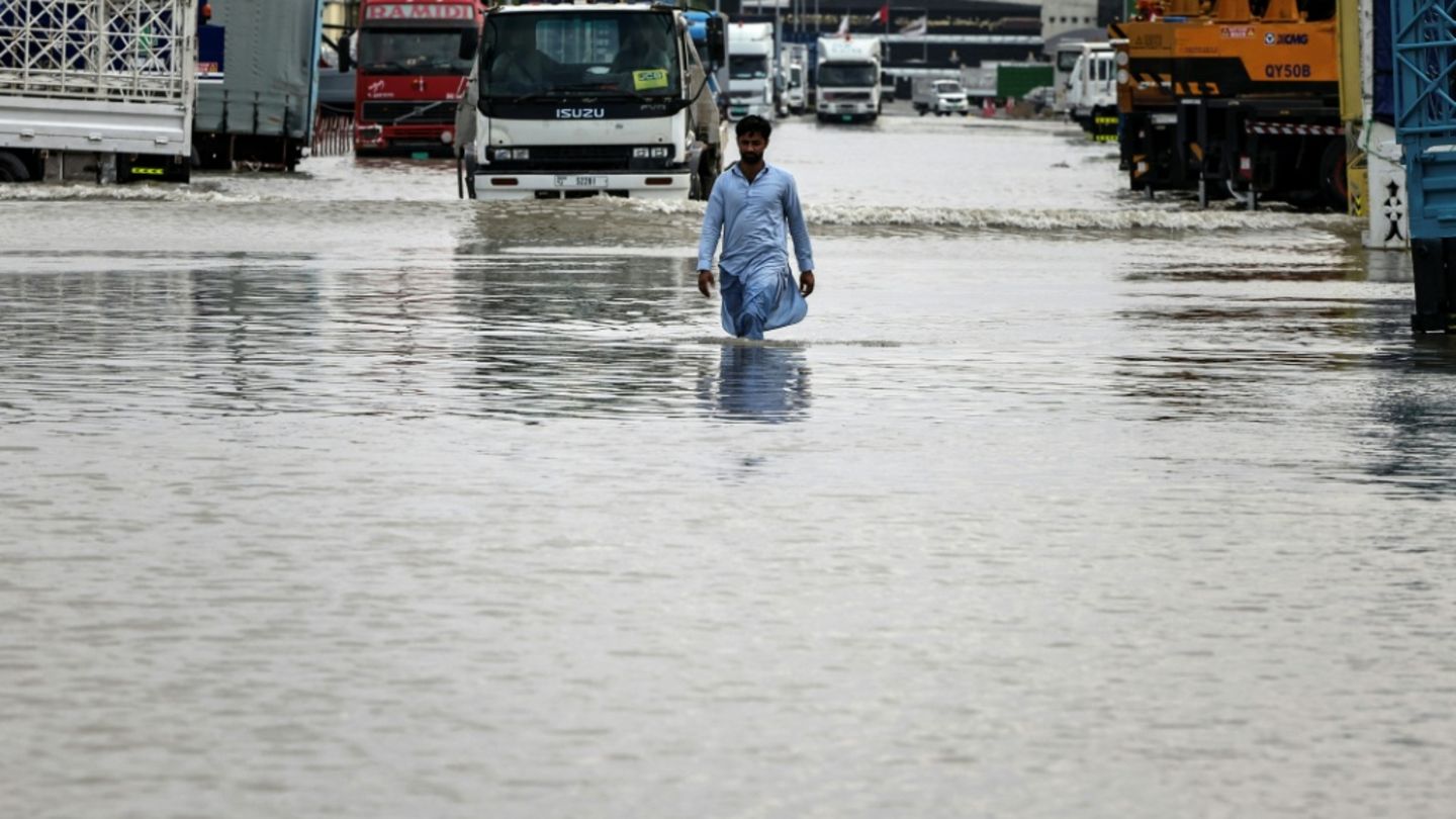 Ein Mann in Dubai watet durch das Wasser